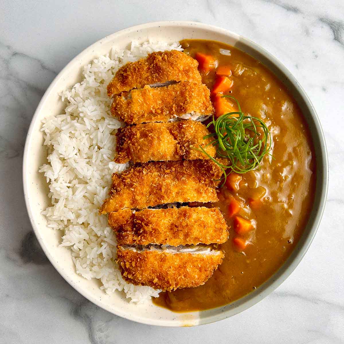 A very tasty looking bowl of katsu curry, a japanese curry dish served over fried chicken with a side of rice. in this case, the chicken is vegan!